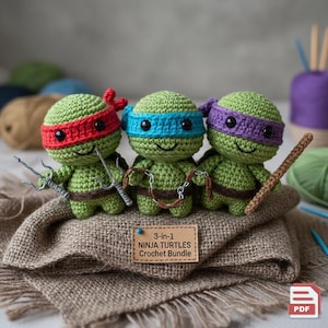 May include: Three handmade crochet Ninja Turtle figures in green, each with a different colored mask: red, blue, and purple. Each turtle holds a weapon. A small sign reads "3-in-1 Ninja Turtles Crochet Bundle".