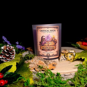 May include: A candle labelled "Critical Wick" and "Arcane Study" sits amidst decorative items. These include purple lavender, pine cones, dice, and greenery, all against a dark backdrop. The scene evokes a fantasy theme.
