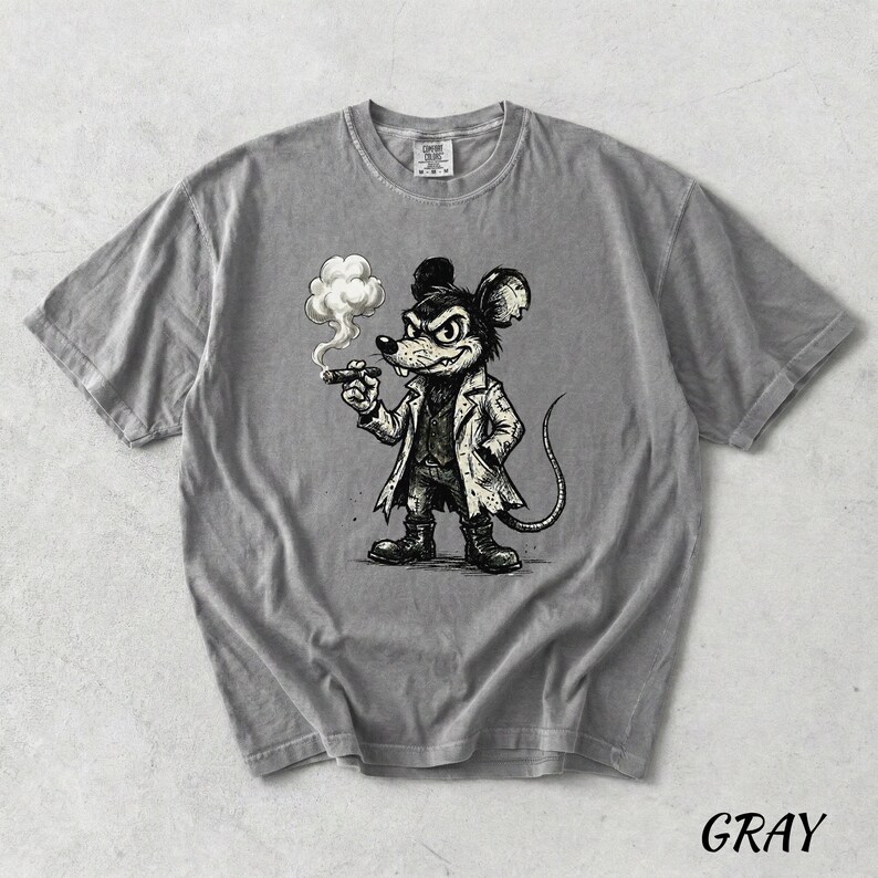 May include: Gray t-shirt featuring a cartoon mouse smoking a cigar. The mouse is dressed in a coat and boots, with a stern expression. The word "GRAY" is printed in the bottom right corner of the shirt.