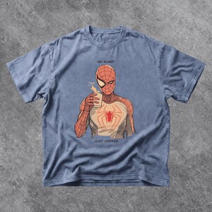 Puede incluir: Camiseta azul claro con un dise&ntilde;o de Spider-Man tomando caf&eacute;. El dise&ntilde;o incluye el texto &laquo;NO SLEEP&raquo; y &laquo;JUST COFFEE&raquo;. El gr&aacute;fico de Spider-Man es rojo, blanco y marr&oacute;n.