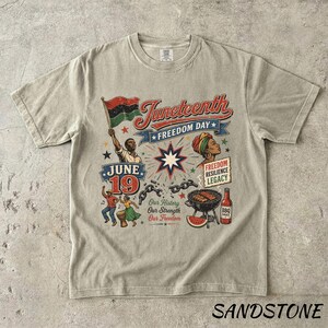 K&ouml;nnte beinhalten: Sandfarbenes T-Shirt mit einer Grafik, die den Juneteenth-Feiertag feiert. Das Design enth&auml;lt den Text "Juneteenth Freedom Day", eine Flagge, Figuren und das Datum "June 19". Zus&auml;tzliche Elemente sind ein Grill, Wassermelone und die Worte "Freedom Resilience Legacy".