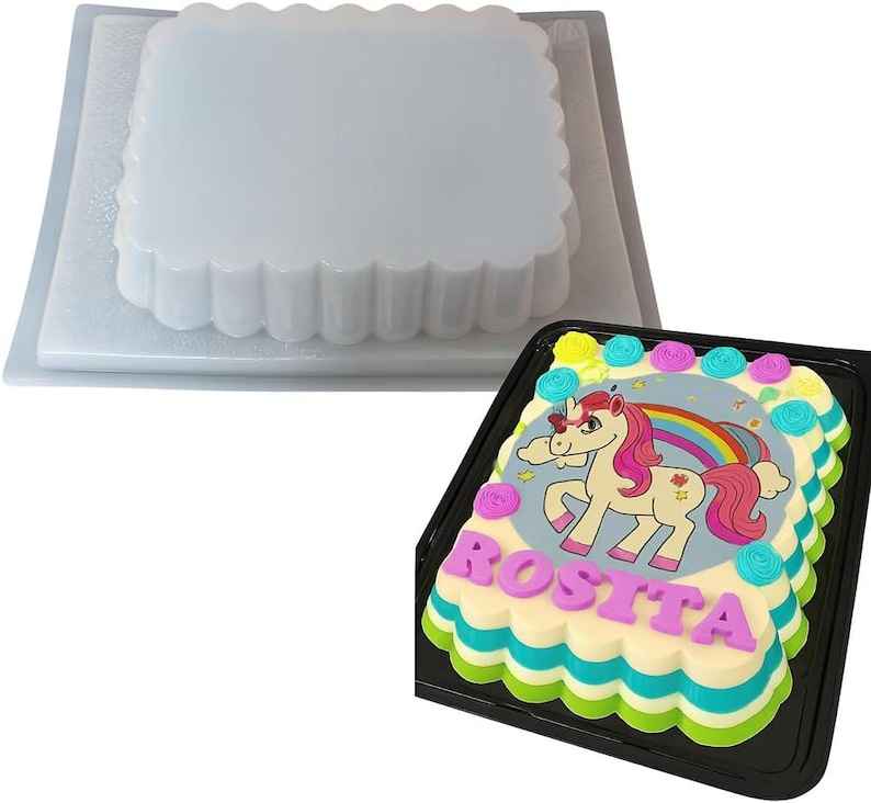 Puede incluir: Un molde de gelatina cuadrado y transparente con borde festoneado se encuentra sobre un pastel decorado. El pastel presenta un dise&ntilde;o de unicornio con un arco&iacute;ris y el nombre "Rosita" en letras rosas.
