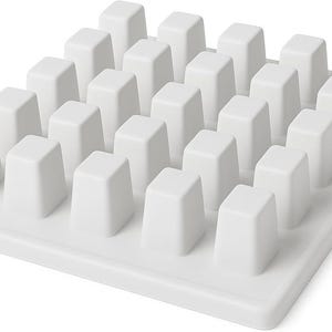 May include: A white, square kitchen gadget with a grid of small, rectangular, raised posts. The posts are evenly spaced and appear to be made of a smooth, solid material. The item is designed to hold or organize items.
