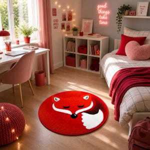 K&ouml;nnte beinhalten: Ein runder roter Teppich mit einem schlafenden Fuchs-Design. Der Fuchs hat wei&szlig;e Akzente und eine schwarze Nase. Der Teppich befindet sich in einem Schlafzimmer mit Schreibtisch, Stuhl und Bett. Der Raum ist in Rot- und Rosat&ouml;nen gehalten.