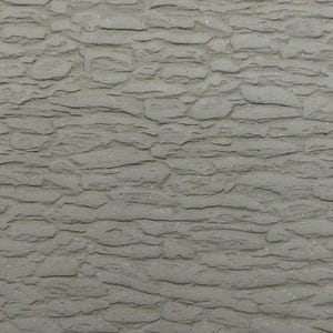 May include: Close-up of a textured, grey stone wall. The surface has a rough, layered appearance with horizontal ridges and a slightly uneven texture. The colour is a muted grey with subtle variations.