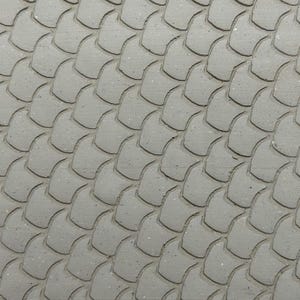 May include: Close-up of a textured, grey surface with a repeating pattern of overlapping, scale-like shapes. The pattern is evenly spaced, creating depth and texture. The surface has a slightly rough, speckled appearance.