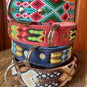 May include: Four colorful dog collars stacked on top of each other. The top collar is turquoise, pink, and white. The second collar is red with green and yellow accents. The third is blue with yellow and white accents. The bottom collar is brown and white.