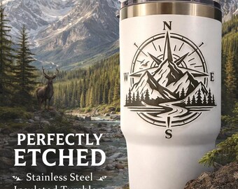 May include: White stainless steel insulated tumbler with a black compass and mountain design. The tumbler has a black lid and a silver rim. The text "PERFECTLY ETCHED" and "Stainless Steel Insulated Tumblers" are also visible.