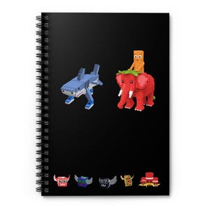 May include: Spiral-bound notebook with a black cover. It features block-style animal figures: a blue and white shark, a red elephant with an orange figure on top, and several small, colourful block figures.