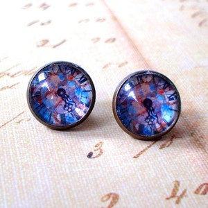 May include: A pair of bronze-colored stud earrings with a blue and pink clock face design.