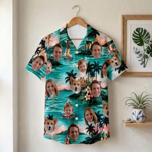 Puede incluir: Camisa hawaiana de manga corta con una escena tropical y caras de personas y perros. La camisa presenta un fondo turquesa con palmeras, veleros y una puesta de sol. La camisa está colgada en una percha de madera.