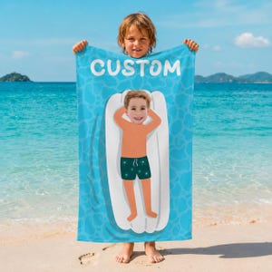 May include: A blue beach towel with the word "CUSTOM" in white, held by a child. The towel features a cartoon illustration of a person on a white pool float. The background is a blue water pattern.