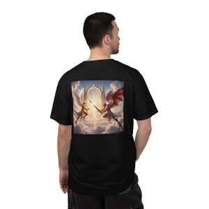 Può includere: T-shirt nero con una grafica quadrata sul retro raffigurante una battaglia tra un angelo e un demone. L'angelo ha ali bianche e il demone ali rosse, sullo sfondo di un cielo nuvoloso e luce intensa.