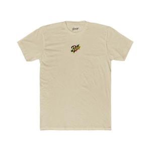 Può includere: T-shirt beige chiaro con scollo tondo. La parola "Breezy" è stampata in piccole lettere nere sulla parte superiore della schiena della maglietta. La parte anteriore della maglietta presenta la parola "Breezy" in un design colorato e stilizzato.