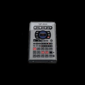 Puede incluir: Un pin de sampler SP-404 plateado con botones rojos y blancos y una pantalla digital que muestra "138". El pin tiene forma rectangular con esquinas redondeadas, sobre un fondo negro.