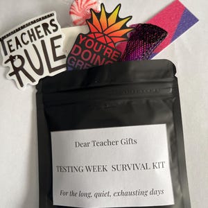 May include: A black pouch labeled "Dear Teacher Gifts" containing a "Testing Week Survival Kit." The kit includes stickers with text, a pineapple-shaped sticker with the words "You're Doing Great," and candies.