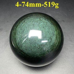 May include: A polished, dark green obsidian sphere. The surface reflects light, revealing a swirling pattern within the stone. The text "4-74mm-519g" is in the upper left corner. The sphere is approximately 2.9 inches in diameter and weighs 18.3 ounces.