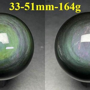 May include: Two polished obsidian spheres, each with a swirling pattern of green, gray, and black. The spheres are approximately 1.3 to 2 inches in diameter and weigh 5.8 ounces. The text "33-51mm-164g" is visible at the top.
