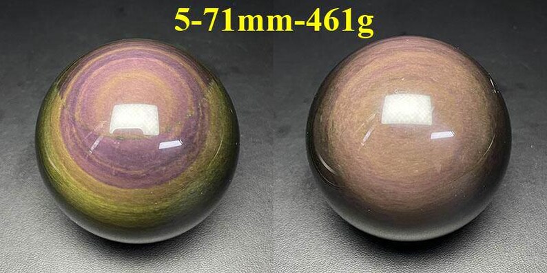 May include: Two polished obsidian spheres. The spheres have a swirling pattern of purple, gold, and brown. The text "5-71mm-461g" is above the spheres. Each sphere is approximately 2.8 inches in diameter and weighs 16.3 ounces.