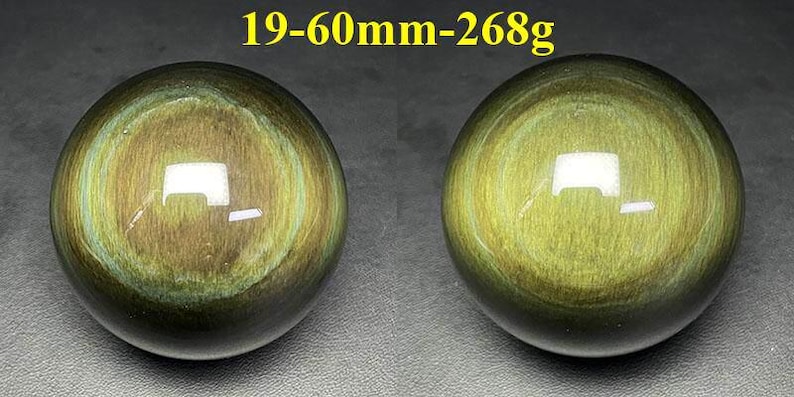 May include: Two polished, spherical gemstones with a golden-green iridescence. The spheres have concentric patterns and a glossy finish. Text at the top reads "19-60mm-268g". These decorative spheres could be used as paperweights or display pieces.
