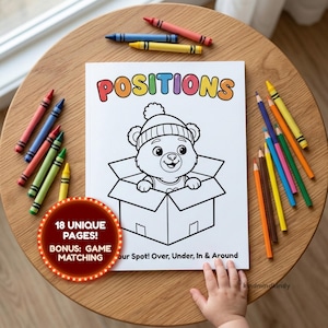 May include: A coloring book titled "POSITIONS" with a cartoon bear in a box, surrounded by crayons and colored pencils. The book includes "18 UNIQUE PAGES!" and a "BONUS: GAME MATCHING" activity. A child's hand is visible.
