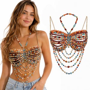 May include: A butterfly-shaped body chain top constructed from multi-colored beads in shades of orange, blue, brown, and cream. The design features a halter neck strap, horizontal beaded rows forming wings, and multiple dangling beaded chains.