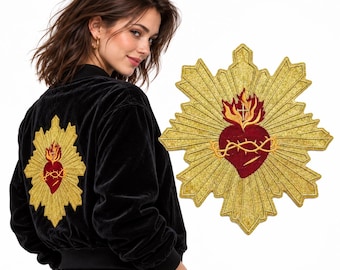 Puede incluir: Una chaqueta bomber de terciopelo negro con un gran parche bordado en la espalda. El parche representa un corazón rojo rodeado por un resplandor dorado, con una corona de espinas y una pequeña cruz sobre el corazón, también mostrado por separado.