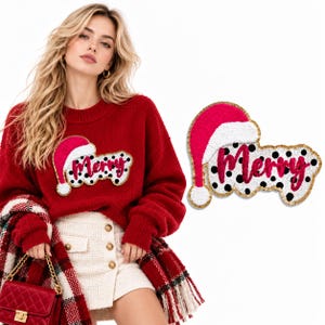 Puede incluir: Un suéter rojo de manga larga con un parche grande que muestra la palabra Merry en letra cursiva rosa, un gorro de Papá Noel rosa y blanco, y un fondo blanco con lunares negros. El parche tiene un borde dorado y se muestra por separado a la derecha.