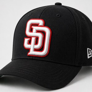 Könnte beinhalten: Schwarze Baseballkappe mit dem weißen und roten "SD" Logo. Die Kappe hat einen gebogenen Schirm und das New Era Logo. Ein klassisches Sportaccessoire für den Alltag.