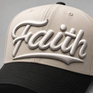 Puede incluir: Una gorra de béisbol beige con visera negra y botón superior negro. El panel frontal presenta la palabra Faith en letras cursivas tridimensionales plateadas en relieve, con un acabado metálico liso y un sutil subrayado decorativo.