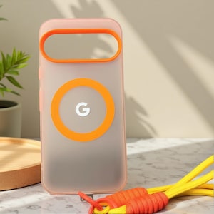 May include: A translucent pink phone case with orange accents, including a circular ring and a rectangular loop. The case features a white "G" logo within an orange circle. A yellow and orange lanyard rests below the case.
