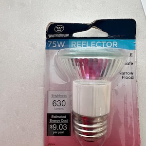 May include: A Westinghouse 75W reflector halogen light bulb in its original packaging. The bulb has a clear glass dome and a white base. The packaging includes the brightness in lumens and the estimated energy cost per year.