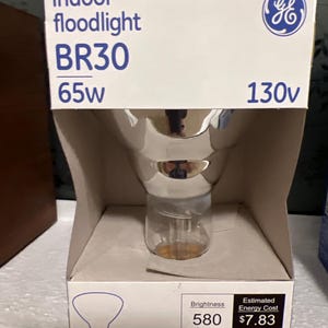 May include: A GE indoor floodlight BR30 65w 130v light bulb in its original packaging. The packaging is white with blue text and a diagram of the bulb. The bulb is silver and clear.