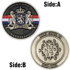 Może przedstawiać: Dwustronna moneta pamiątkowa. Strona A przedstawia herb z napisem "DIENST VERVOER & ONDERSTEUNING" i "NEDERLAND". Strona B ma ilustrację koronawirusa z napisem "INZET COVID 19" i "2020-2022".