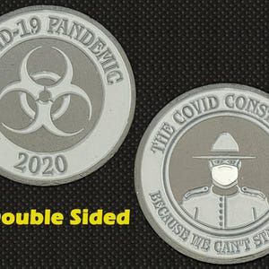 Puede incluir: Moneda plateada de doble cara con el texto "COVID-19 PANDEMIC 2020" y un símbolo de riesgo biológico en una cara. La otra cara muestra un oficial enmascarado y el texto "THE COVID CONSTABLE BECAUSE WE CAN'T STAY HOME."