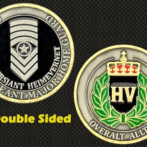 Puede incluir: Moneda militar de doble cara con tonos plateados y dorados. Un lado presenta un fondo negro con una insignia plateada y texto. El otro lado tiene un borde dorado, una corona verde y una corona. El texto "Doble cara" es en amarillo.