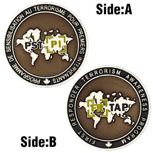 May include: Two-sided bronze-colored coin with text and a world map design. Side A reads "PROGRAMME DE SENSIBILISATION AU TERRORISME POUR PREMIERS INTERVENANTS" and "PST PI". Side B reads "FIRST RESPONDER TERRORISM AWARENESS PROGRAM" and "FR TAP".