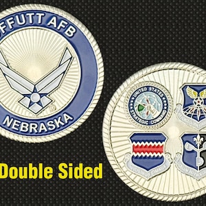 May include: Double-sided coin featuring the Offutt AFB Nebraska emblem in blue and silver. The reverse side displays four military emblems. The coin has a detailed design and a metallic finish.