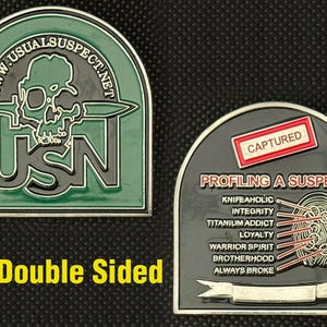 Może przedstawiać: Dwustronna moneta z zielonym i czarnym wzorem. Jedna strona przedstawia czaszkę z nożem oraz tekst "USN" i "WWW.USUALSUSPECT.NET". Druga strona mówi "CAPTURED" i "PROFILING A SUSPECT".
