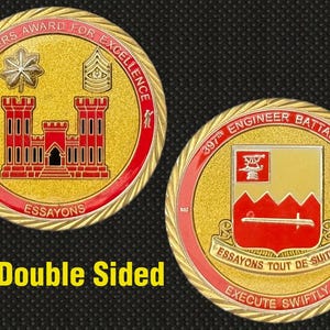 May include: Double-sided gold-colored coin with red and black accents. One side features a castle and text "COMMANDERS AWARD FOR EXCELLENCE". The other side displays a crest and text "397th ENGINEER BATTALION".