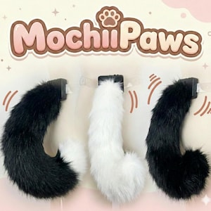 Puede incluir: Tres colas de piel sintética esponjosas, negras, blancas y negras con puntas blancas, montadas en tiras de plástico transparente. Las colas son curvas y tienen una apariencia juguetona. La marca "MochiiPaws" se muestra arriba.