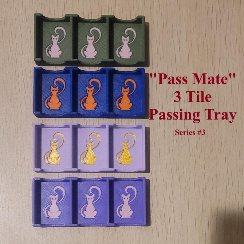 May include: Four rectangular 3-tile passing trays labeled Pass Mate Series #3. Each tray features three compartments with a cat silhouette graphic. The trays are colored olive green, blue, light purple, and dark purple with contrasting cat icons.