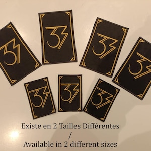 Peut inclure: Plusieurs écussons rectangulaires noirs avec un motif "33" doré et une bordure dorée. Le texte "Existe en 2 Tailles Différentes / Available in 2 different sizes" est visible.
