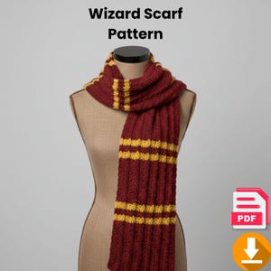 Op de afbeelding: Bordeauxrode en gouden gebreide sjaal op een mannequin. De sjaal heeft verticale geribbelde secties met horizontale gouden strepen. De tekst "Wizard Scarf Pattern" staat bovenaan de afbeelding.