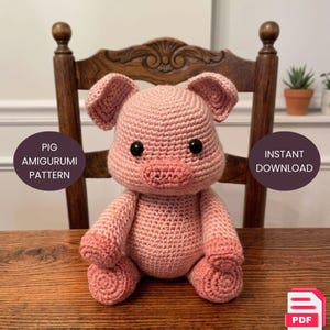 May include: A handmade pink amigurumi pig sits on a wooden surface. The pig has large black eyes, small ears, and a detailed snout. The text "PIG AMIGURUMI PATTERN" and "INSTANT DOWNLOAD" are displayed on the image. A PDF icon is in the bottom right corner.