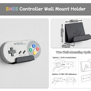 Pu&ograve; includere: Un supporto da parete nero per controller SNES con larghezza 67mm, altezza 56mm e profondit&agrave; 44mm. Il supporto sostiene un controller grigio Nintendo Super Famicom. L'immagine include etichette di testo per due opzioni di montaggio: trapano o adesivo.