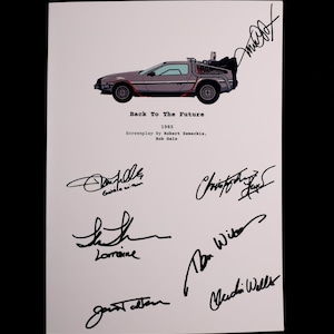 May include: A print featuring the DeLorean time machine from the movie "Back to the Future." The image includes the film's title, year, and screenplay credits, along with several signatures. The car is gray with red accents.
