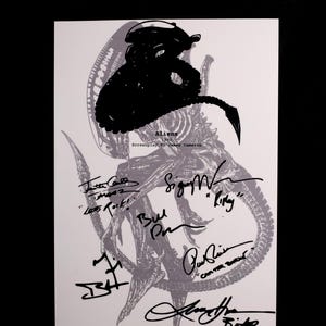 May include: A black and white print of the movie "Aliens" featuring a detailed illustration of the alien creature. The print includes the movie title, screenplay credits, and several signatures in black ink. The background is a light gray.