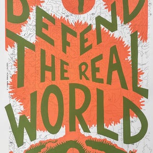 May include: A green and orange print with the text "Defend the Real World" on a topographic map background. A bird flies over a red sun. A bug and a pepper are at the bottom of the print.