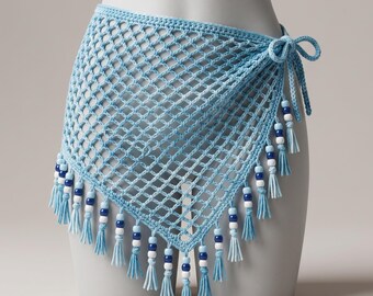 May include: A light blue crochet wrap skirt with a net-like design. The skirt is adorned with tassels and beads in shades of blue and white along the bottom edge. It is tied at the side with a bow.